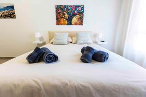 Una gran cama blanca con almohadas azules. en Casa Joan, en Denia