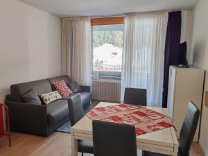 a living room with a couch and a table at AL18 bilocale in Santa Caterina Valfurva