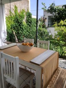 un bol d'oranges posé sur une table avec deux chaises dans l'établissement Entre Jazmines & Glicinas, à Lobos