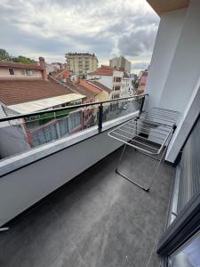 普里什蒂纳Central Lux Apartmens的坐在大楼阳台上的椅子