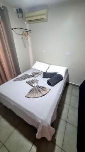 a bedroom with a bed with a white blanket at Edícula Roma - Casa de hóspedes in Campo Mourão