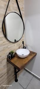 a bathroom with a white sink and a mirror at Edícula Roma - Casa de hóspedes in Campo Mourão