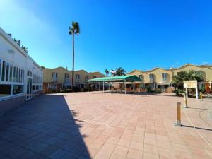 een grote binnenplaats met een gebouw en palmbomen bij Green Holiday Island in Maspalomas