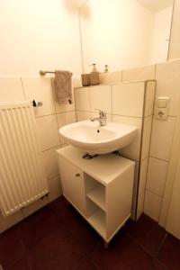 une salle de bain blanche avec un lavabo et un miroir dans l'établissement Charming Old Town Apartment - Central and Cozy, à Passau 9 autres photos