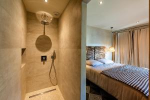 ein Schlafzimmer mit einem Bett und einer Dusche in der Unterkunft Les Terrasses de MAJORAC - Le Cottage in Bozouls + 5 Fotos