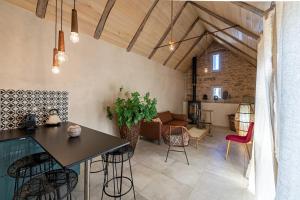 eine Küche und ein Wohnzimmer mit Tisch und Stühlen in der Unterkunft Les Terrasses de MAJORAC - Le Cottage in Bozouls