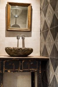 ein Badezimmer mit einem Waschbecken und einem Spiegel auf einer Ablage in der Unterkunft Les Terrasses de MAJORAC - Le Cottage in Bozouls