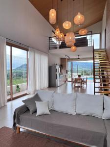 a living room with a large couch and a dining room at Casa Vista Serrana in São Pedro