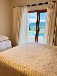 a bedroom with a bed and a large window at Casa Vista Serrana in São Pedro +37 photos