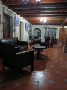 a living room with couches and a table and chairs at Jardín de Los Sueños Quinta San Felipe in Cataltzul