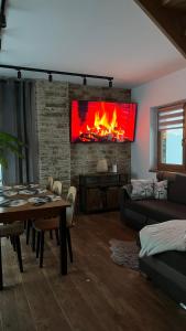 un salon avec une cheminée et une table dans l'établissement Domek Góralski Reset, à Gliczarów Górny