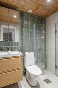 une salle de bain avec toilettes et douche en verre dans l'établissement Stylish marine studio, balcony, parking in Lauttasaari, à Helsinki