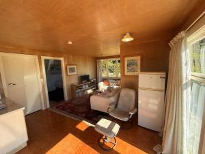 Una sala de estar con un sofá y un refrigerador. en Estuary View - Peaceful Onekaka Retreat, en Onekaka
