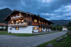 a house with a gambrel roof on a road at Gästehaus zum Thoma in Kreuth