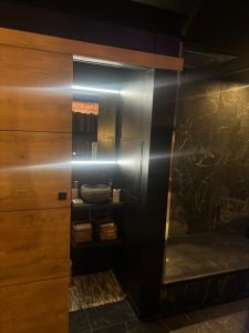 a bathroom with a wooden cabinet with a mirror at L'écrin Secret Suite & NETFLIX Aubagne-Cassis-Marseille in Aubagne