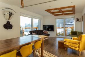 ein Wohnzimmer mit einem Holztisch und gelben Stühlen in der Unterkunft HARLEY FAMILY APARTAMENT in Muszyna