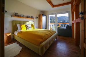 ein Schlafzimmer mit einem großen Bett und einem großen Fenster in der Unterkunft HARLEY FAMILY APARTAMENT in Muszyna