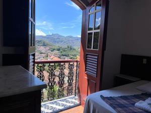 an open door to a balcony with a view at Pousada Casa dos Contos in Ouro Preto +15 photos