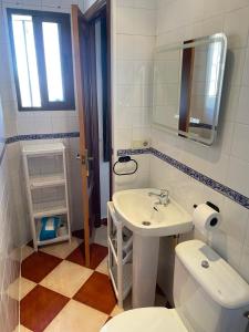 une salle de bain avec un lavabo, des toilettes et un miroir dans l'établissement Zahara Lovers, à Zahara de la Sierra