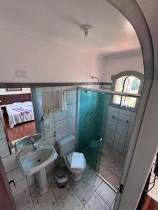 a bathroom with a sink and a toilet and a mirror at Pousada Casa dos Contos in Ouro Preto