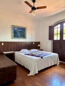 a bedroom with a bed with a ceiling fan at Pousada Casa dos Contos in Ouro Preto