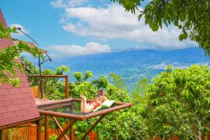 a woman is laying on a bed in the mountains at Glamping Entre Mangos in La Mesa