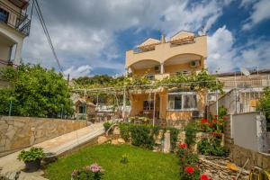una casa con un jardín delante de ella en Apartments Saldun, en Trogir