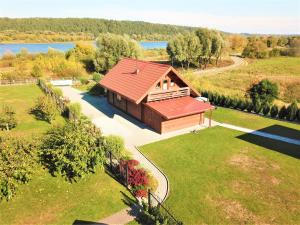 a small cabin with a red roof on a lawn at Pas Rimute in Zapyškis