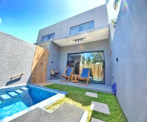 a house with a swimming pool next to a house at LOFT Mar 101 - Com Piscina Privativa a Poucos Passos de Vilas Gastronômicas Polo de Artesanato e Associação Peixe-boi in Pôrto de Pedras