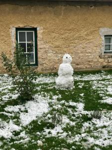 une statue de bonhomme de neige assise devant un bâtiment dans l'établissement Lapillo Vendégház, à Köveskál