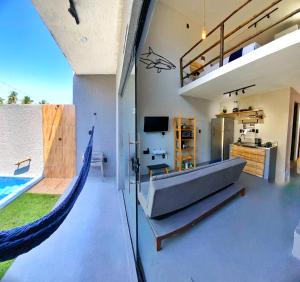 a living room with a couch and a hammock at LOFT Mar 101 - Com Piscina Privativa a Poucos Passos de Vilas Gastronômicas Polo de Artesanato e Associação Peixe-boi in Pôrto de Pedras