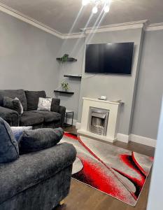 a living room with a couch and a tv on a wall at King Edward 3 bed house ideal for contractors in Darlaston