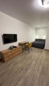 a living room with a television and a bed and a table at Sunset apart in Kremenetsʼ