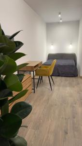een slaapkamer met een bed en een tafel en een gele stoel bij Sunset apart in Kremenets