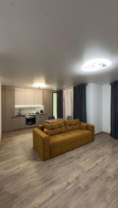 een woonkamer met een bank en een keuken bij Sunset apart in Kremenets