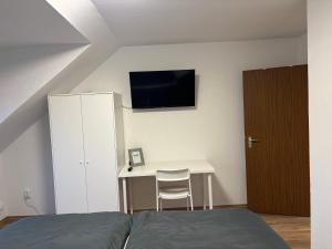a bedroom with a bed and a desk with a tv at Wohnung in Würzburg Rimpar I Netflix & TV I Kaffee I Tee I Brettspiele in Rimpar