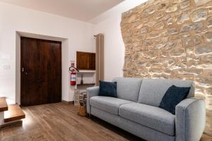a living room with a couch and a stone wall at L'Angolo della Torre in Bevagna