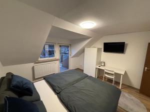 a bedroom with a bed and a desk with a tv at Wohnung in Würzburg Rimpar I Netflix & TV I Kaffee I Tee I Brettspiele in Rimpar +12 photos