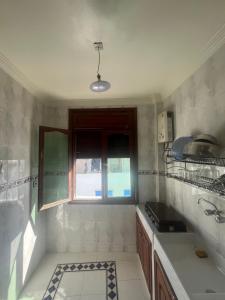 塔哈佐特Blue Beach Apartments的带水槽和窗户的厨房 更多8张照片