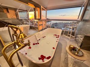 a bathroom with a bath tub with red flowers in it at Villa D' Republic Dubrovnik - Infinity Pool & Old Town Views in Dubrovnik