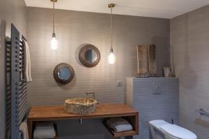 ein Bad mit Waschbecken, WC und Beleuchtung in der Unterkunft Les Terrasses de MAJORAC - La Grange in Bozouls + 6 Fotos