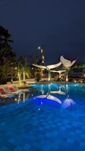 una gran piscina por la noche con sillas y sidx sidx sidx sidx en Hostería Mandála, en Puerto López