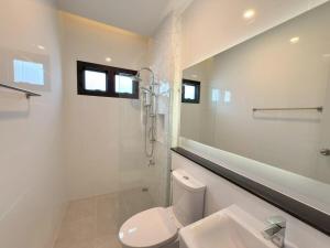 a bathroom with a shower and a toilet and a sink at Tropical home close to nature and city in Ban Mai I