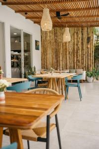 a restaurant with wooden tables and blue chairs at Vikara in Olón +48 photos