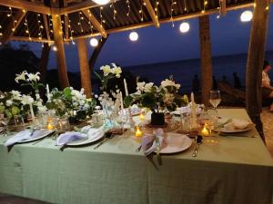 a table set up for a meal at the beach at CABIN C at Bigang Munti Beach Resort in Bootin