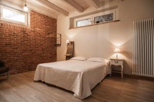 Un dormitorio con una cama y una pared de ladrillo. en Acini Sparsi, en Montalenghe 12 fotos más