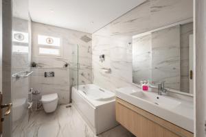 a white bathroom with a sink and a toilet at The White Coconut Stay in Cairo +35 photos