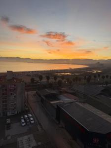 ein Sonnenuntergang über einer Stadt mit Autos auf einem Parkplatz in der Unterkunft alojamiento en coquimbo in Coquimbo