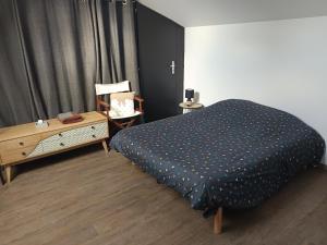 une chambre avec un lit et une table avec une chaise dans l'établissement chambre d'hôte Léonie, à Saint-Riquier