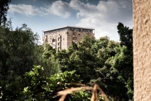 a tall building in the middle of some trees at The White Coconut Stay in Cairo